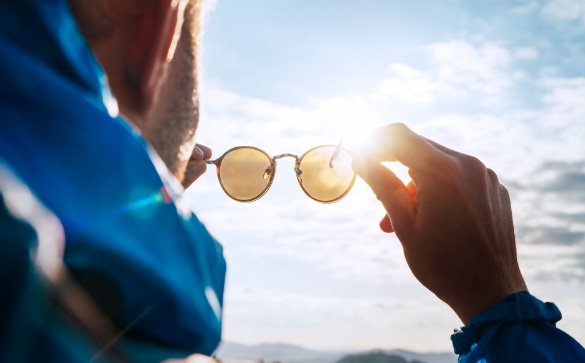 Man holding polarised sun glasses 