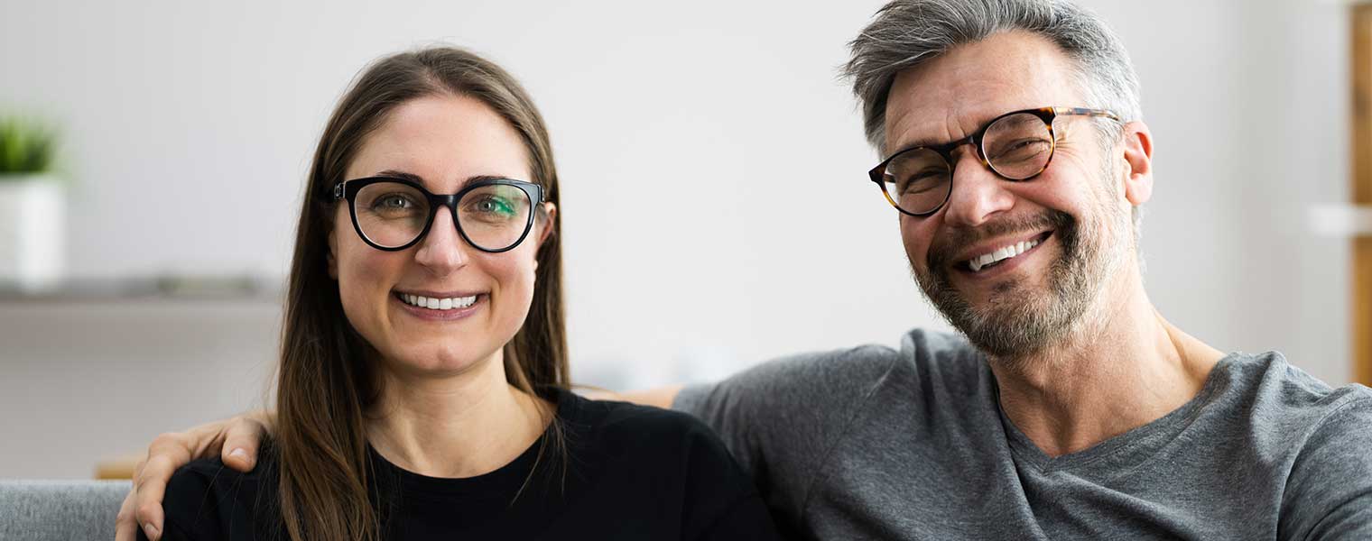 Couple wearing glasses sitting on the sofa.