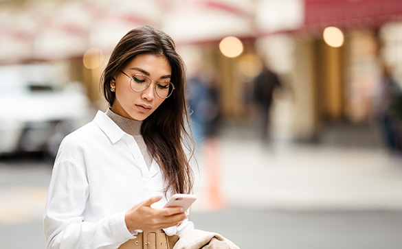 Woman using her smartphone wearing glasses